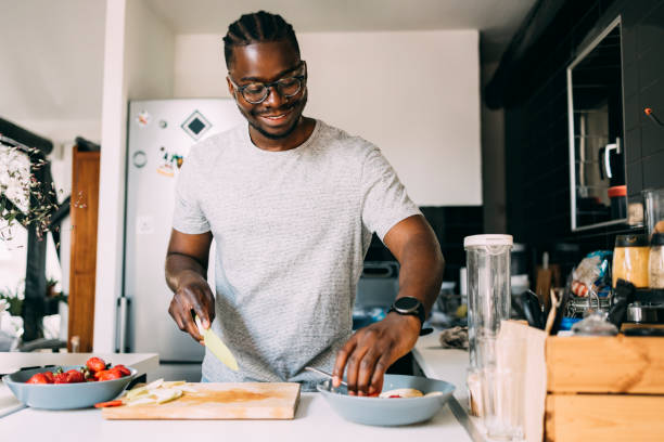 Young adult confidently preparing a meal in their own kitchen
